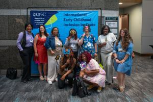 Participants pose in front the Inclusion Institute banner.